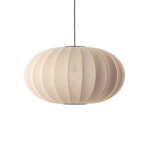 Oval lampe i lys beige med strikket overflade og sorte ledning. Vertikale striber ses tydeligt.